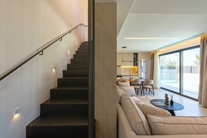 Ein modernes Interieur mit Treppe, einer Couch und einem Essbereich.