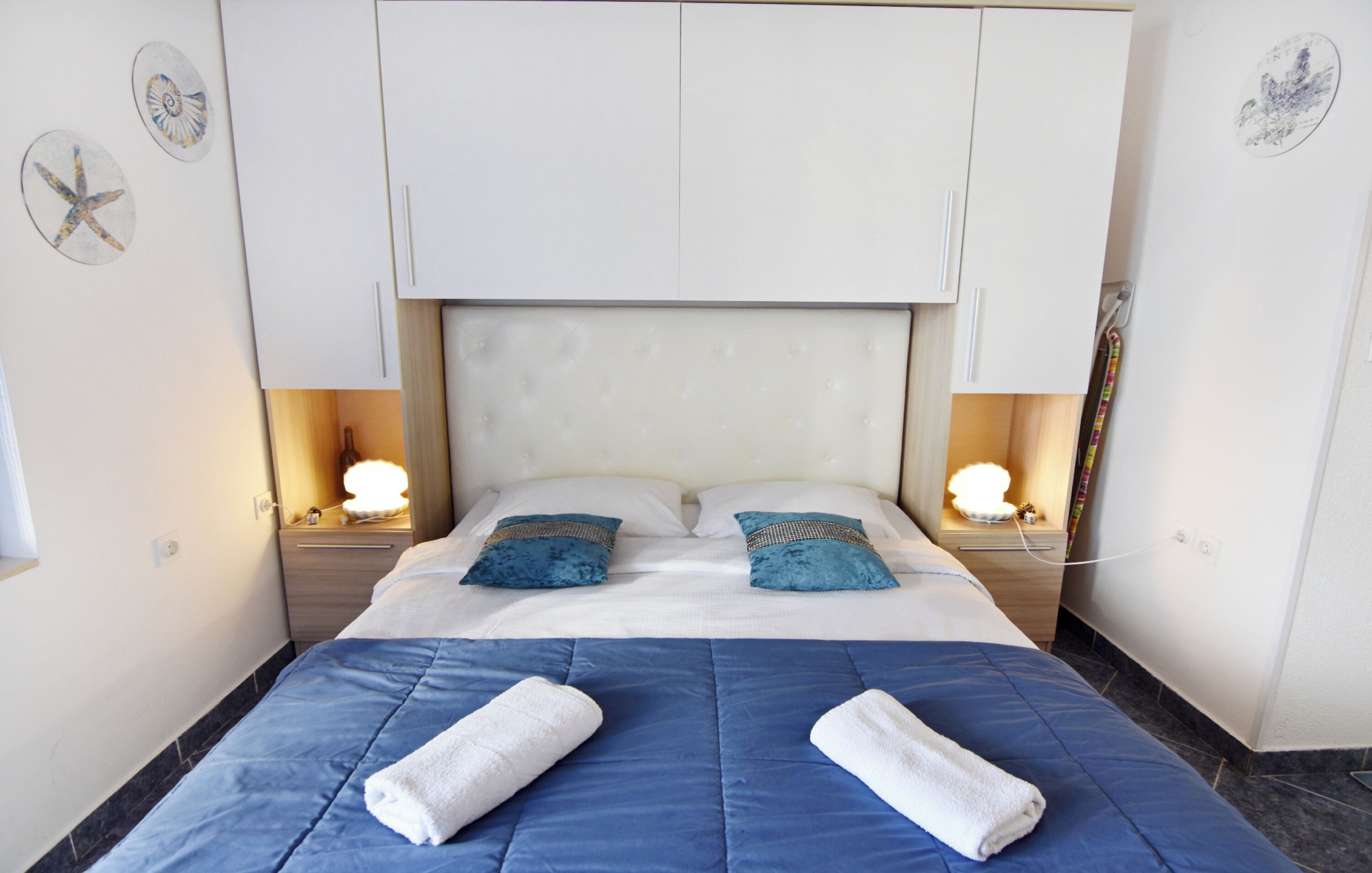 A hotel room with a large bed, two bedside tables with lamps, and decorative wall art.