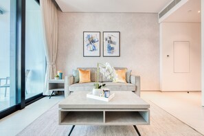 Ein modernes Wohnzimmer mit Sofa, Couchtisch und Kunstwerk an der Wand.