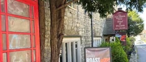 A red telephone booth, a stone building, and a sign advertising Sunflower Roasts.