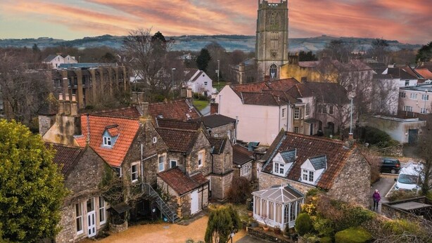 A historic town with traditional architecture, a prominent church tower, and a well-maintained public square.