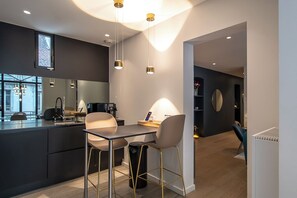 A modern kitchen with a dining area, a large mirror, pendant lights, and a view of the city. - ✨ Elegance & comfort in the heart of Annecy ✨ (Annecy)