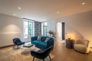 A modern living room with a teal sofa, two armchairs, a coffee table, and a lamp. - ✨ Elegance & comfort in the heart of Annecy ✨ (Annecy)