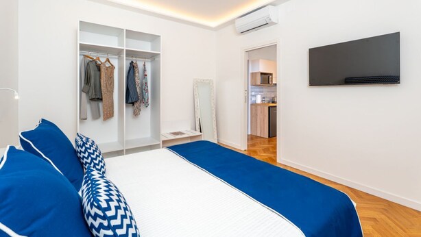 A modern bedroom with a bed, wardrobe, and a TV mounted on the wall. - Nicea Apartment - Sorrento center (Sorrento)