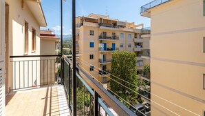 A balcony with a view of neighboring buildings and a tree. - Nicea Apartment - Sorrento center (Sorrento)