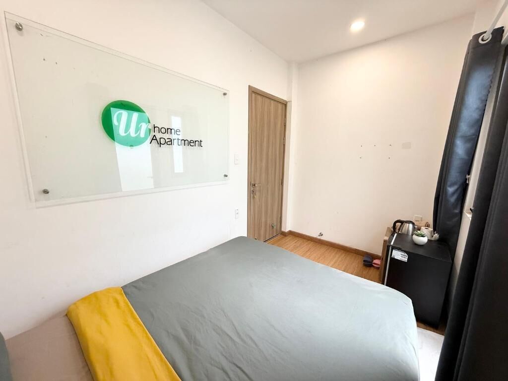 Un dormitorio con cama, un escritorio pequeño, un armario y una ventana con un letrero.