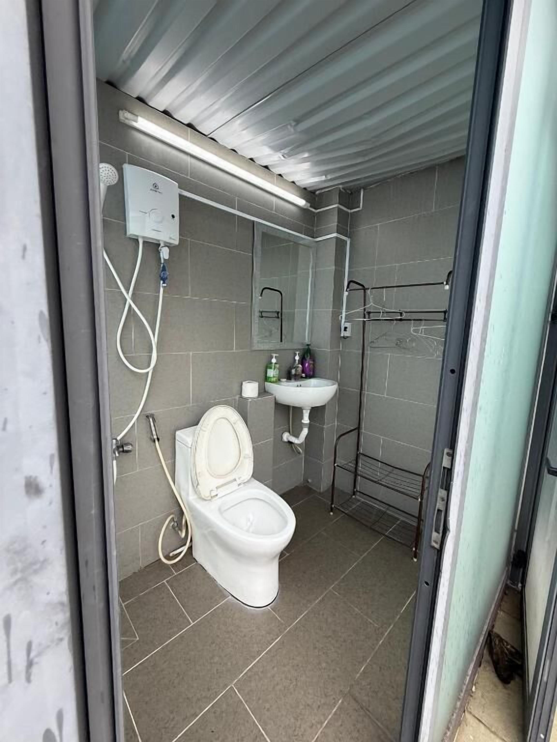 A compact bathroom with a toilet, sink, and shower.