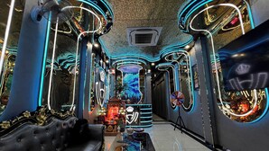 A luxurious interior with a plush black sofa, a glass coffee table, and neon light accents. - Haven Hotel (Ho Chi Minh City)