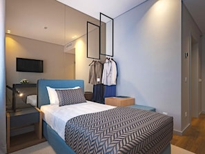 Een moderne slaapkamer met een bed, nachtkastje, televisie en spiegel.