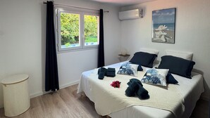 Une chambre à coucher avec un lit, une fenêtre, un climatiseur fixé au mur et un tableau accroché au mur.