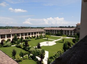 A courtyard with a building featuring multiple arches and a central open space. - Apartment Chervo Golf Uno (Lombardia)