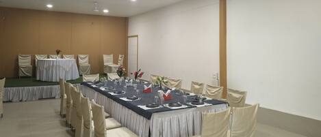 A conference room with a long table, chairs, and ceiling lights.