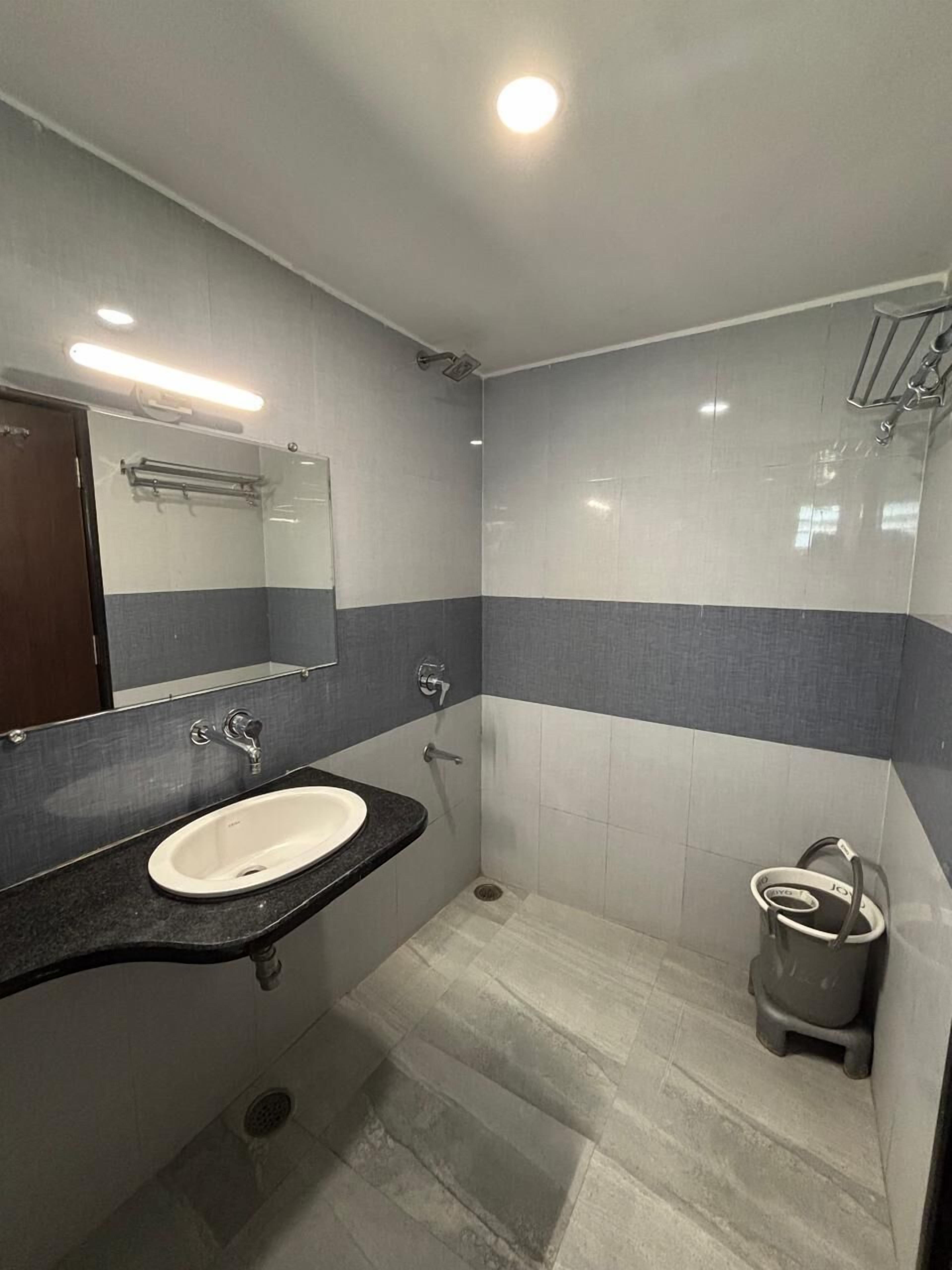 A modern bathroom with a sink, mirror, and shower.