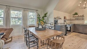 Eine moderne Küche mit Essbereich, Holzboden und großen Fenstern.