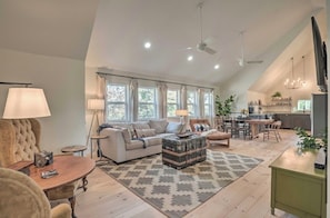 Un salon spacieux comprenant un canapé, une table basse et un coin repas avec des chaises.