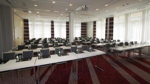 A conference room with multiple tables, chairs, and a projector screen. - 4 Person Holiday Park Home in Neu-isenburg (Neu-Isenburg)