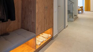 A modern interior with a wooden bench, a coat rack, and a staircase leading to another room. - IGMAR Villas & Aparts  (Tashkent)