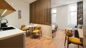 A modern hotel room with a kitchen, dining area, and a sofa. - IGMAR Villas & Aparts  (Tashkent)