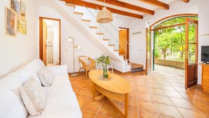 A modern living room with a staircase, a sofa, a coffee table, and a TV. - Holiday Home 'Ca N'Antonia' citrus farm stay (Sóller)