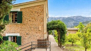 A stone building with a staircase, a small window with shutters, and a view of a mountainous landscape. - Holiday Home 'Ca N'Antonia' citrus farm stay (Sóller)