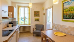 Eine moderne Küche mit Fenster, einem Stuhl, einem Esstisch und einem Gemälde an der Wand.