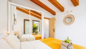 Un dormitorio con cama, un espejo y una puerta que da a un balcón.