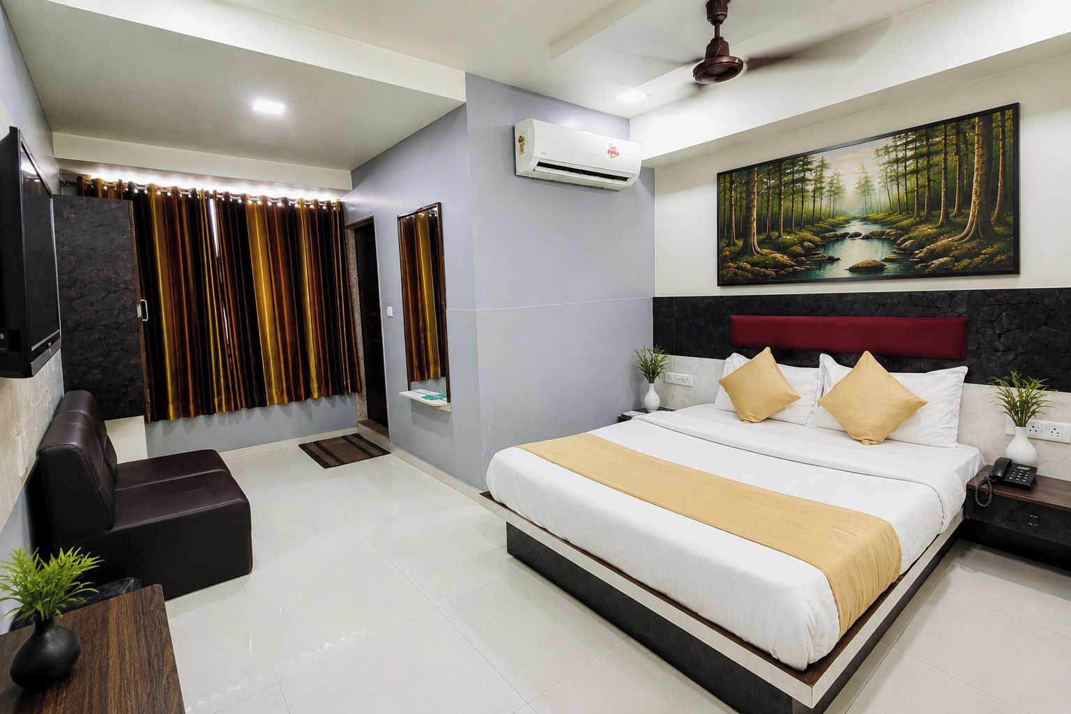 A modern hotel room with a large bed, a TV, a ceiling fan, and a painting of a forest.