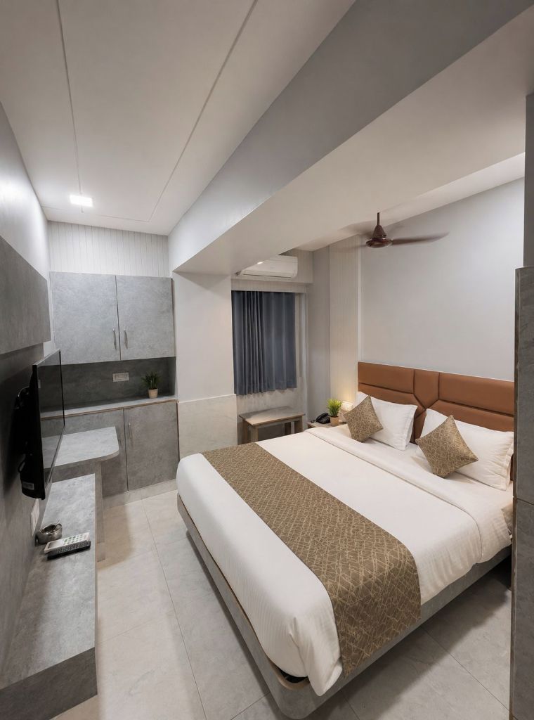 Une chambre d’hôtel moderne équipée d’un lit, d’une table de chevet, d’une télévision et d’un coin cuisine.