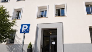 Rakennuksessa on pysäköintikyltti, portti ja useita ikkunoita.