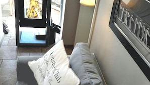 A room with a fireplace, a framed picture on the wall, and a cushion with text. - Ferienhaus fur Zwei mit Landlichem Charme (Fehmarn)