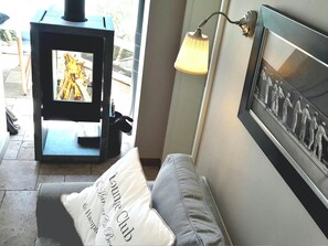 Ein Zimmer mit Kamin, einem gerahmten Bild an der Wand und einem Kissen mit Schrift.