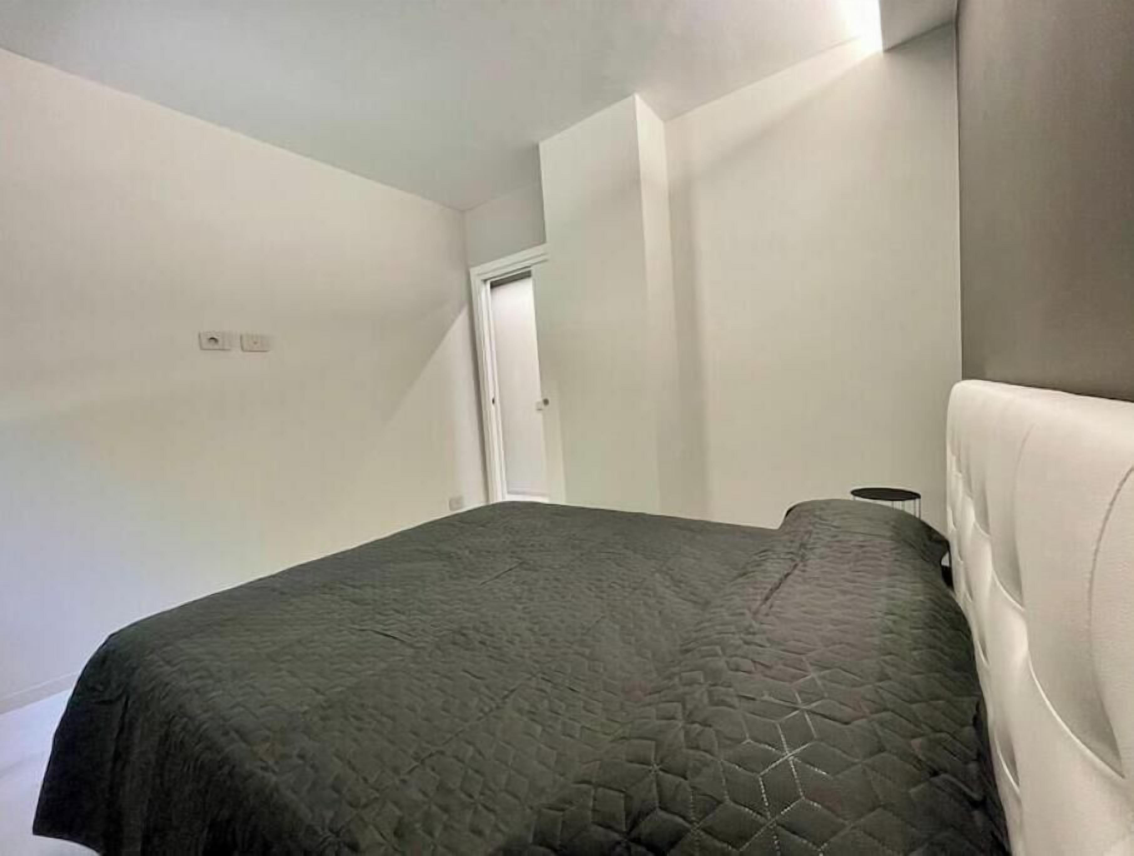 Una camera da letto con un letto, una porta e un lampadario.