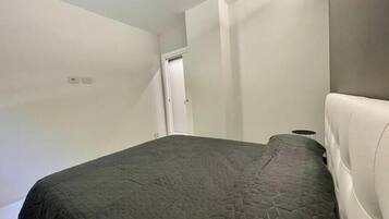 Una camera da letto con un letto, una porta e un lampadario.