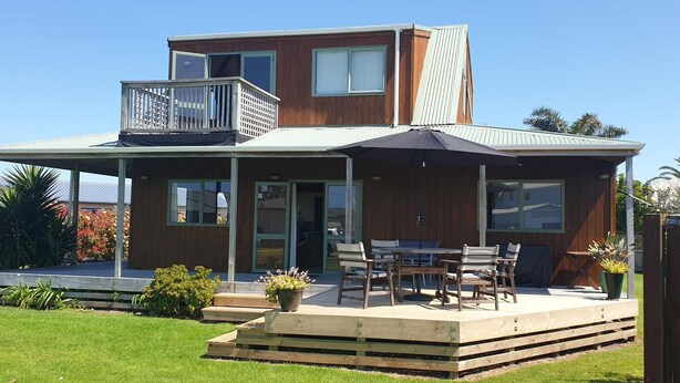 A two-story house with a covered patio, a balcony, and a sliding glass door.