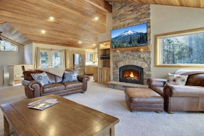 A cozy living room with leather sofas, a fireplace, and a large TV. - 20 East Butte-Sunriver, Oregon: Hot Tub, BBQ, WiFi, SHARC Aquatics, Tubing Hill, Mt. Bachelor, Golf, Deschutes River, Tennis, Bike Paths (Sunriver)