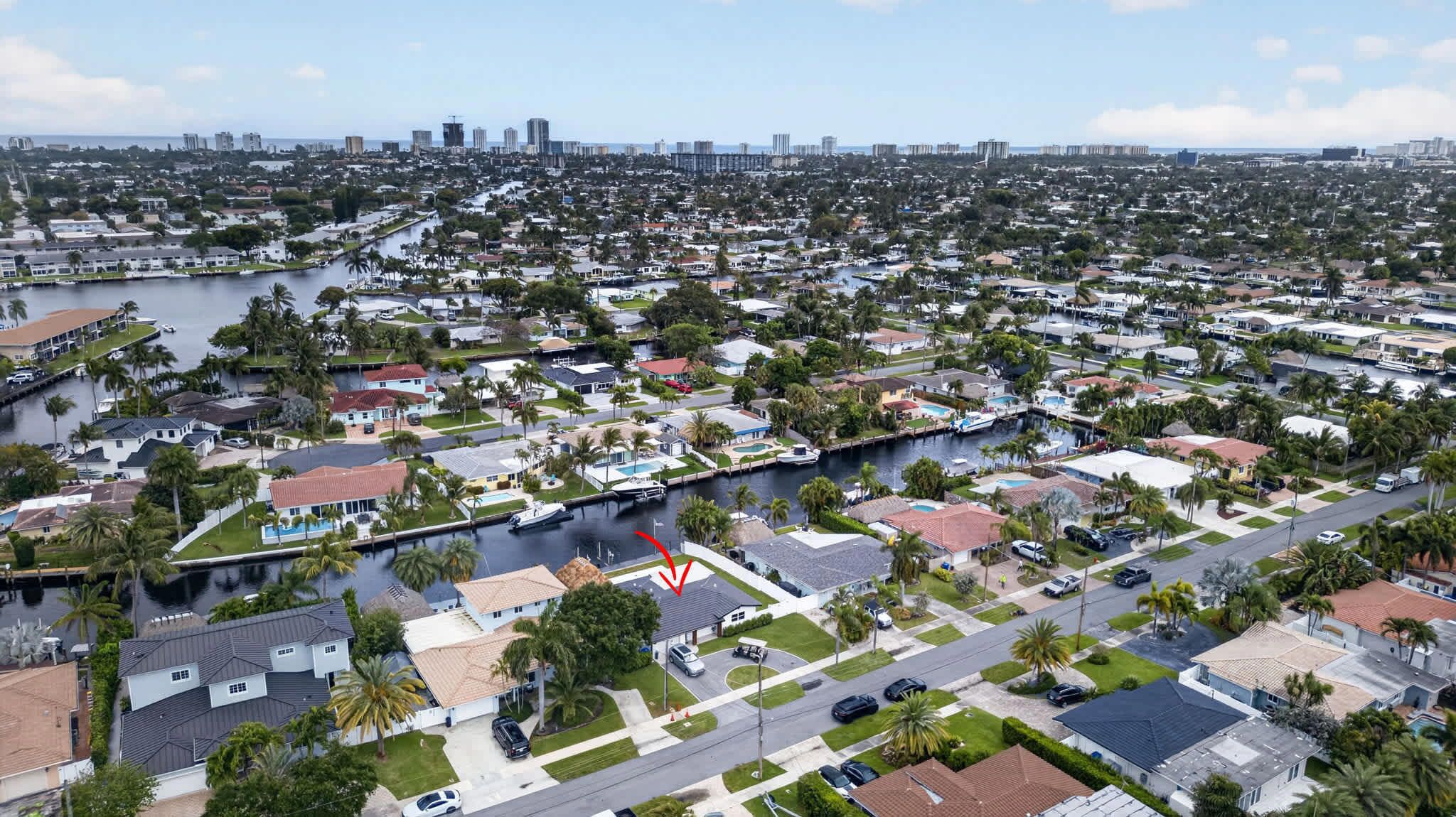 A residential area with houses, a canal, and a city skyline in the background.