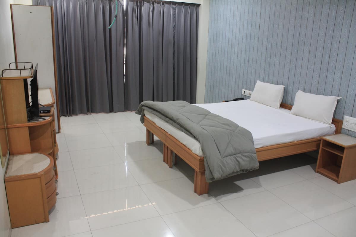 Un dormitorio con cama, mesitas de noche, armario y espejo.