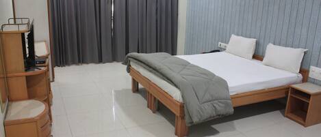 Une chambre à coucher avec un lit, des tables de chevet, une armoire et un miroir.