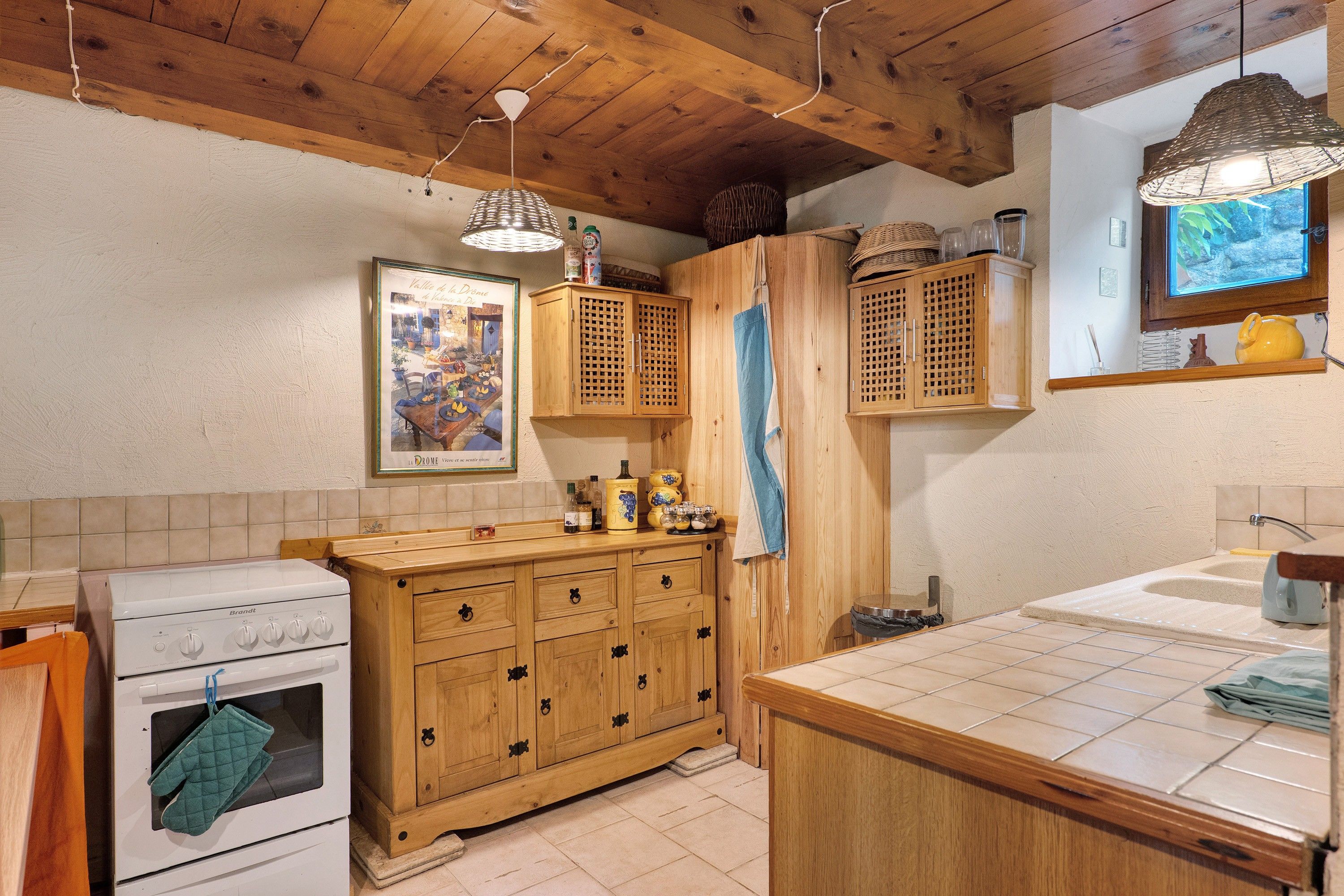 A kitchen with wooden cabinets, a stove, and a window.
