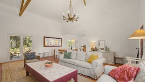 A spacious living room with a white sofa, a wooden coffee table, and a chandelier. - Apartment 'Monte Do Poço Country House' with Private Pool, Wi-Fi and Air Conditioning (Erra)