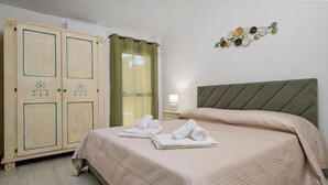 Un dormitorio con cama, armario, mesita de noche y un adorno en la pared.