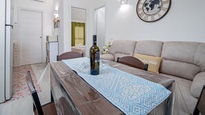 Una sala de estar con una mesa de madera, un sofá, un reloj y un espejo.