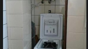 A compact bathroom with a white toilet, a white water heater, and a small cabinet. - Private Beach Apartment WiFi- MorroJable- 2 Bedrooms (Morro Jable)
