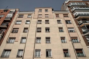 A multi-story building with a uniform facade, numerous windows, and balconies. - Retiro VI (Madrid)
