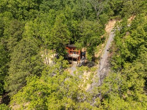 An aerial view of a cabin surrounded by dense forest, with a dirt path leading to it. - Smoky Sunset Getaway -Brand New Beautiful Mountain Cabin (Sevierville)