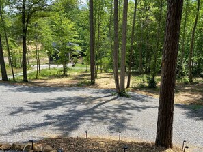 A campground with gravel paths, trees, and a building in the background. - Smoky Sunset Getaway -Brand New Beautiful Mountain Cabin (Sevierville)