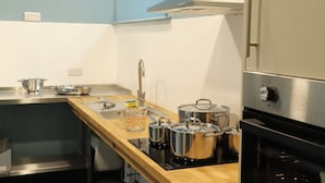 Una cocina moderna con electrodomésticos de acero inoxidable, encimera de madera y horno empotrado.