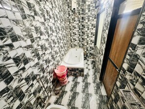 Un baño con bañera, inodoro y zona de ducha.