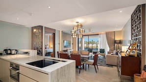 A modern hotel room with a kitchen, dining area, and living room. - Angsana Oceanview Residences Building 2 in Laguna by Banyan Living (Choeng Thale)