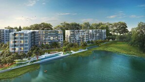 A modern apartment complex with multiple buildings, a central water feature, and surrounding greenery. - Cassia Residences Building 2 in Laguna by Banyan Living (Choeng Thale)